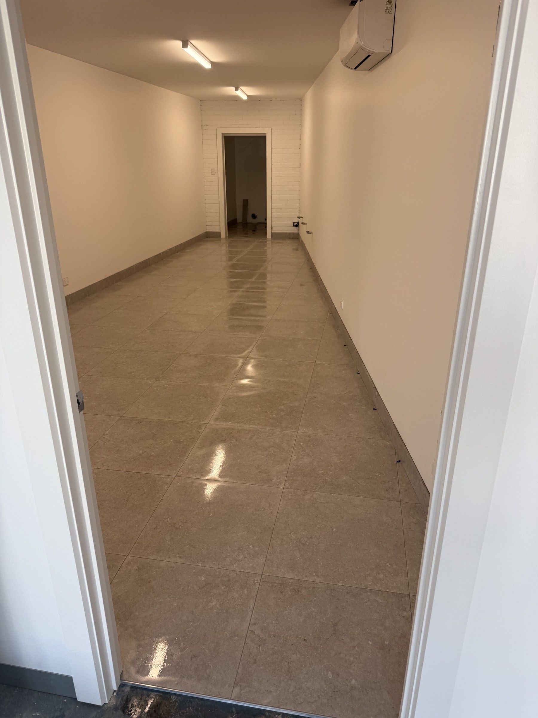 Glossy large-format floor tiling in a commercial corridor